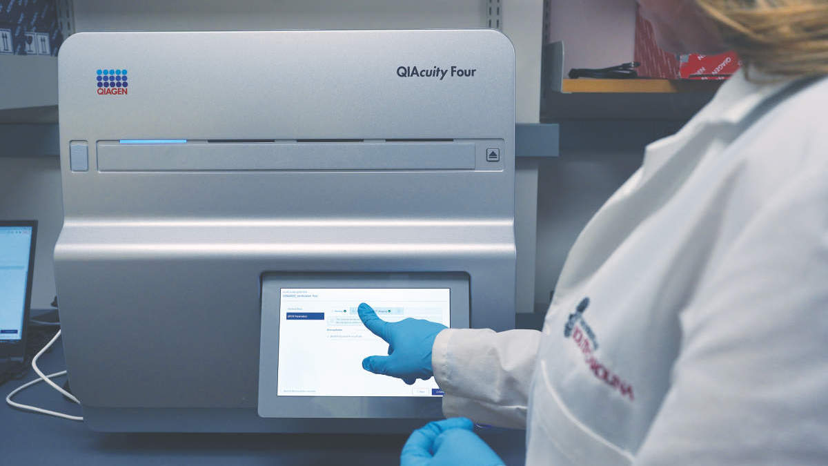 a person standing infront of QIAGEN QIAcuity Four